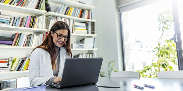 Mujer joven leyendo un ebook en una biblioteca virtual