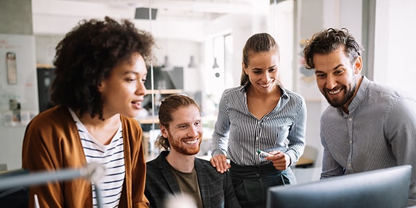 Grupo de colaboradores de una empresa frente a una computadora realizando cursos de desarrollo profesional Grupo de colaboradores de una empresa frente a una computadora realizando cursos de desarrollo profesional