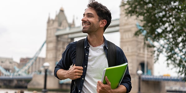 Hombre joven con libros en la mano en Londres