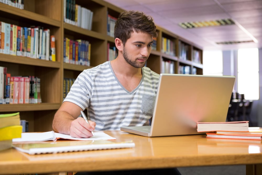 Student studying in the library with laptop at the university Student studying in the library with laptop at the university
